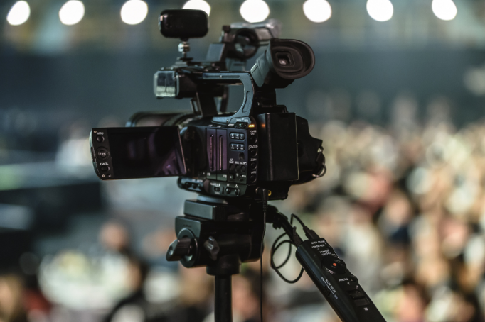 Close up of a digital video camera mounted on tripod.